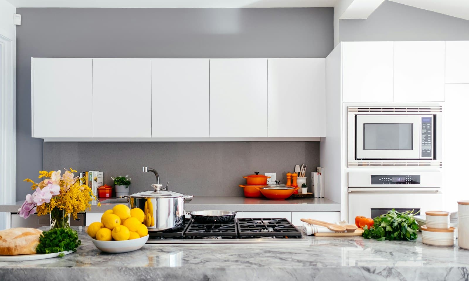 A bright kitchen with marble counters and white cabinetry