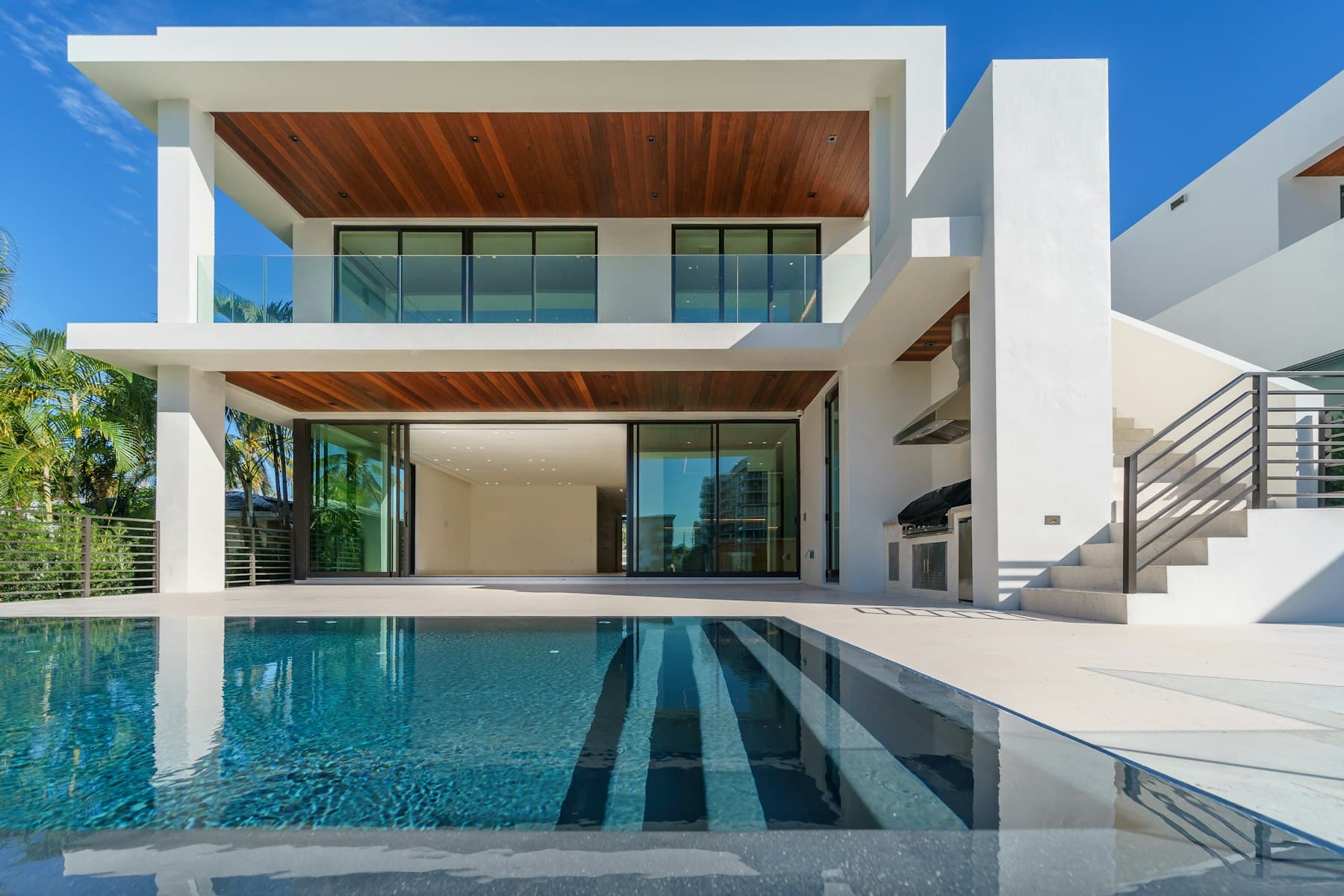 A white modern house with a pool and open glass walls
